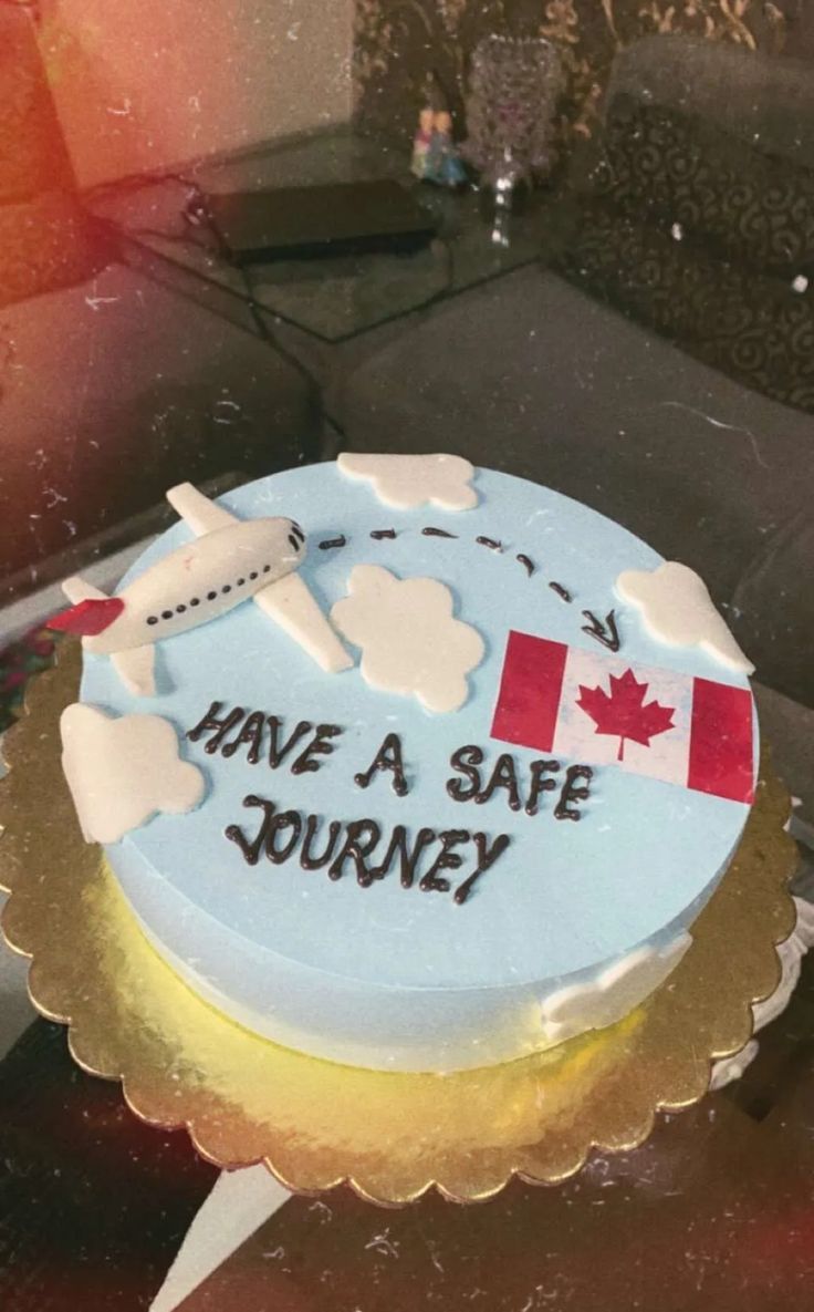 a cake that says have a safe journey on the side with a plane and canadian flag