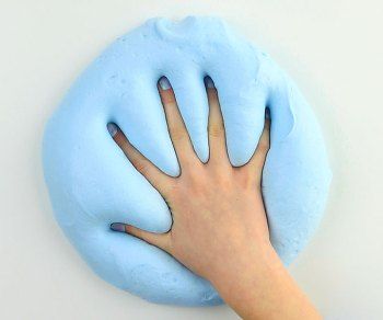 a person's hand on top of a blue doughnut shaped like a hand