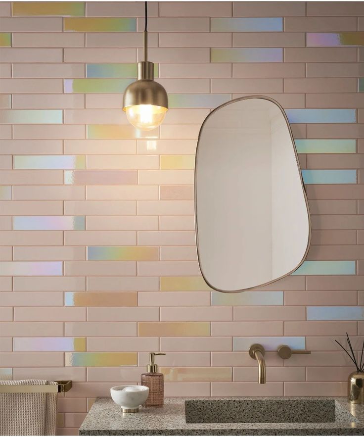 a bathroom sink with a mirror above it and a light hanging from the ceiling over it