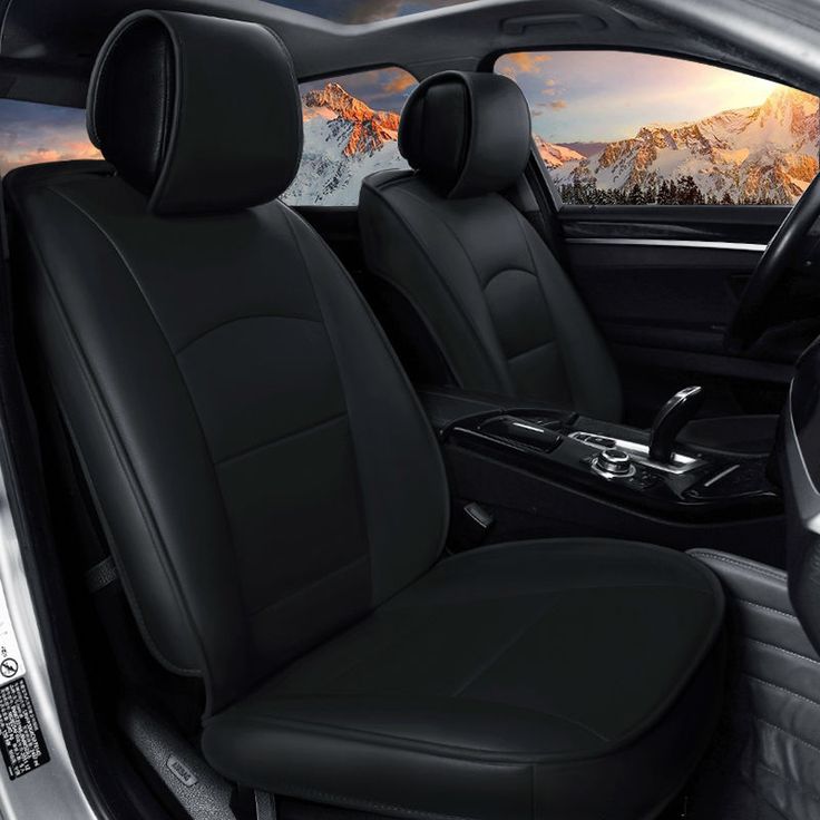 the interior of a car with black leather seats and mountains in the backgroud