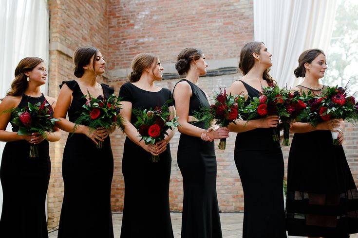 a group of women standing next to each other holding bouquets