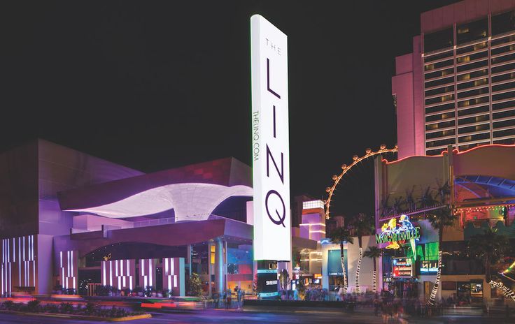 the las vegas sign is lit up at night in front of hotels and casinos