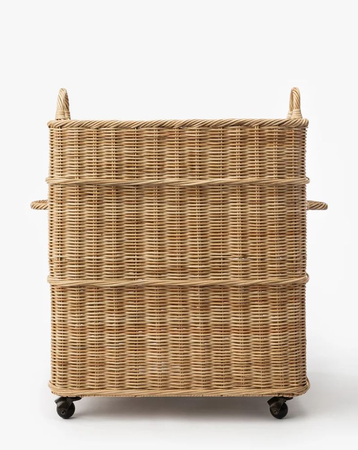 a wicker basket with wheels and handles on the bottom, against a white background