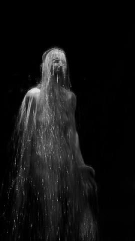 a man standing in the rain with his head covered by water