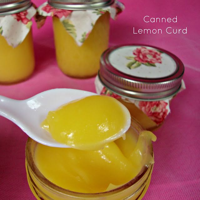 a spoon full of lemon curd next to some jars