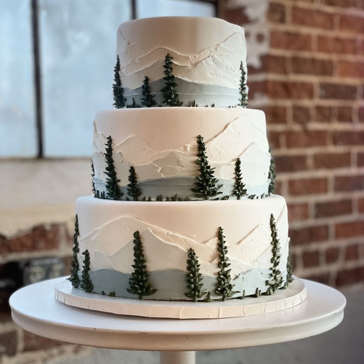 a three tiered cake with trees on it