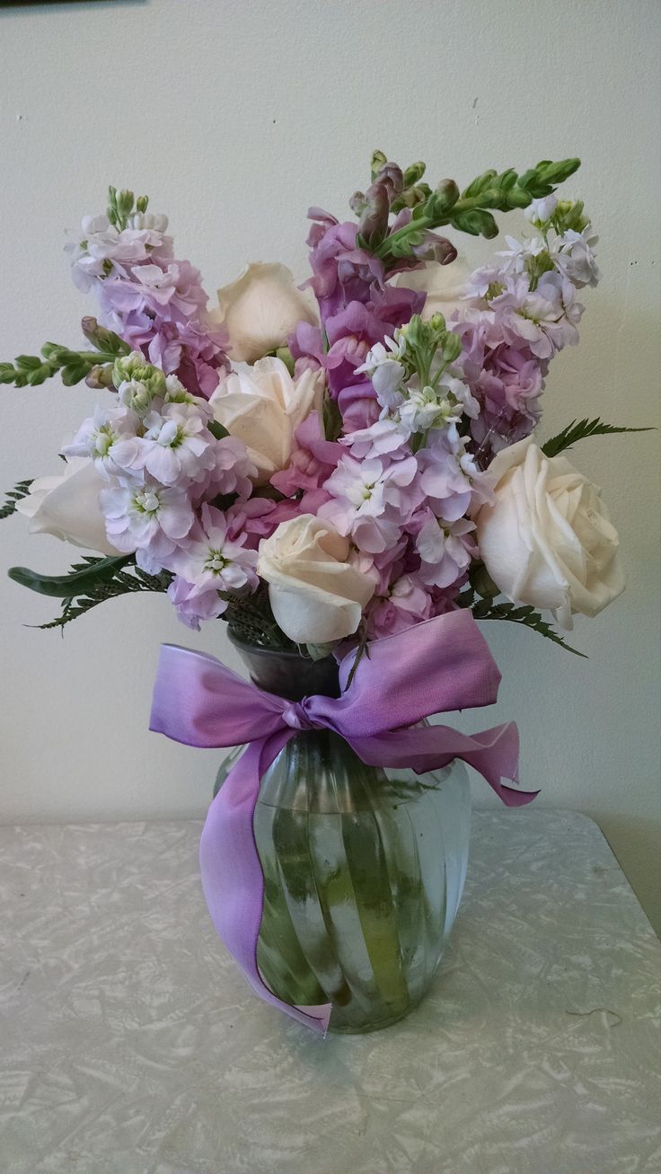 a vase filled with lots of purple and white flowers