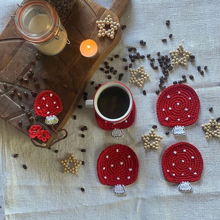 four crocheted coasters sitting on top of a table next to a cup of coffee