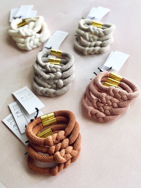 four different colored hair ties sitting on top of a table