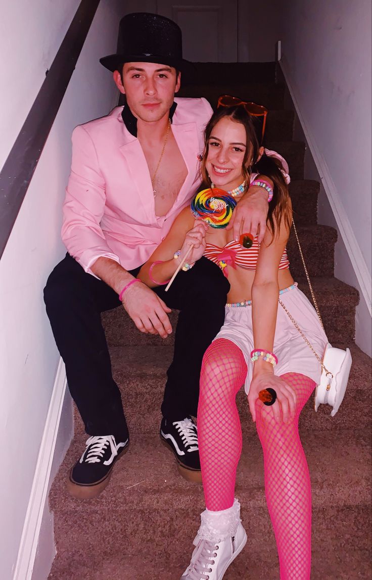 the man and woman are sitting on the stairs with candy in their hands as they pose for a photo