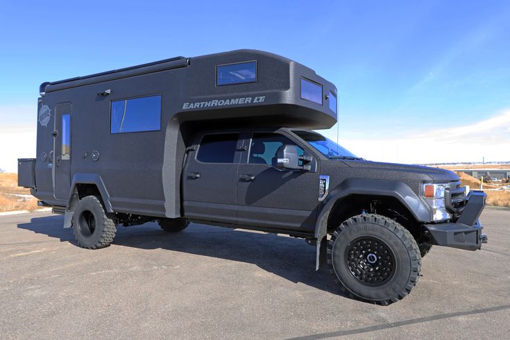 a black truck with a camper attached to it's bed