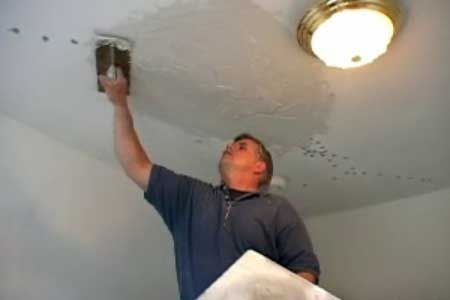 a man is painting the ceiling in his home