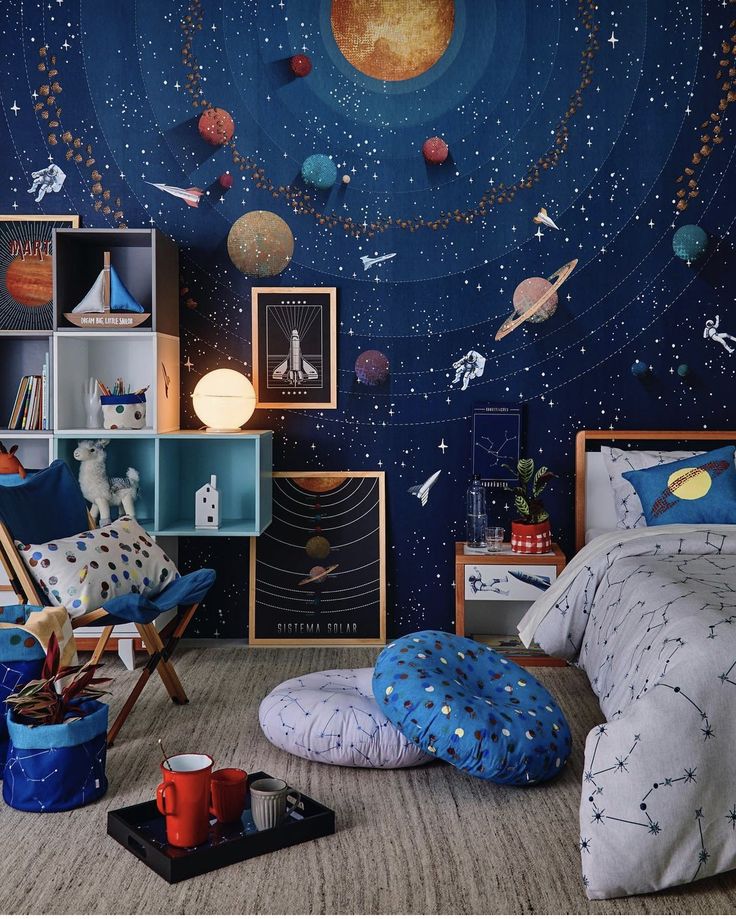 a child's bedroom with space themed wallpaper