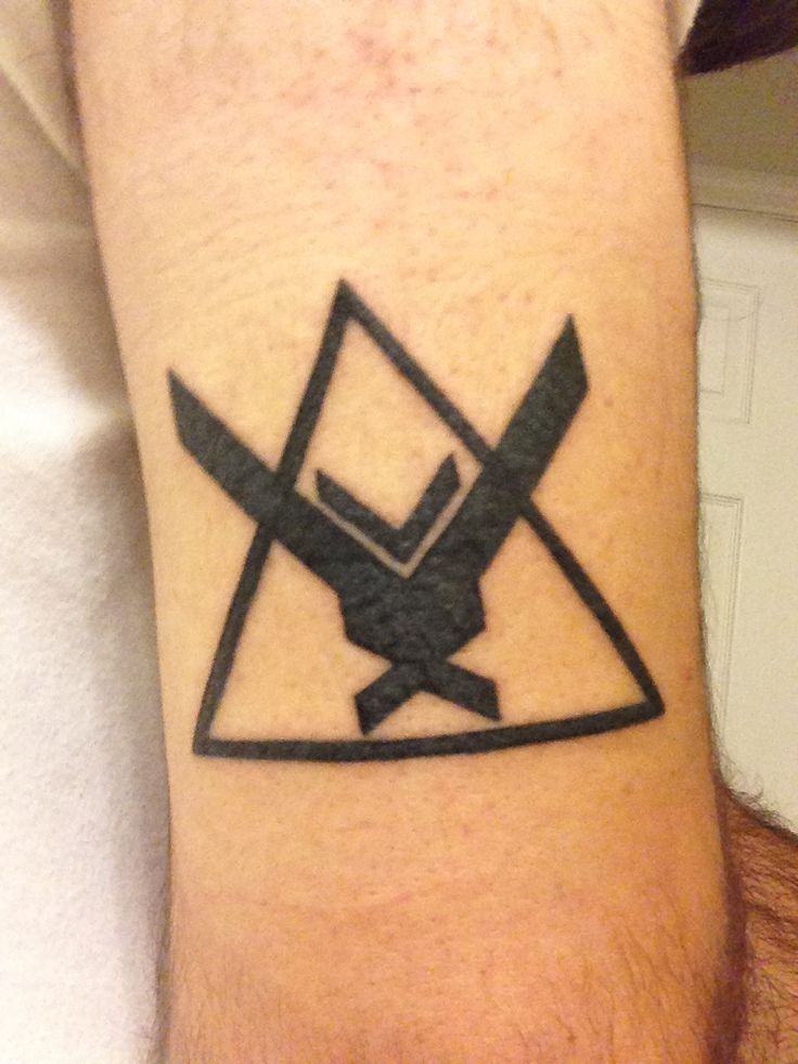 a man with a tattoo on his arm has scissors in the shape of a triangle