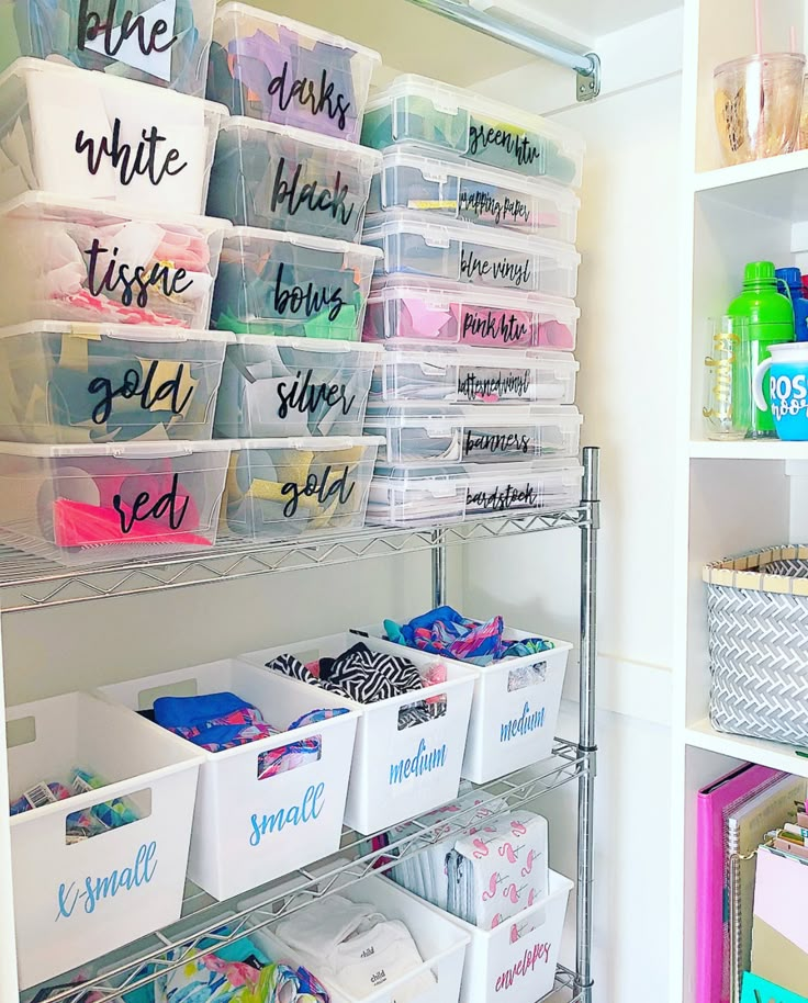 the shelves are filled with plastic bins and other storage containers for crafting supplies