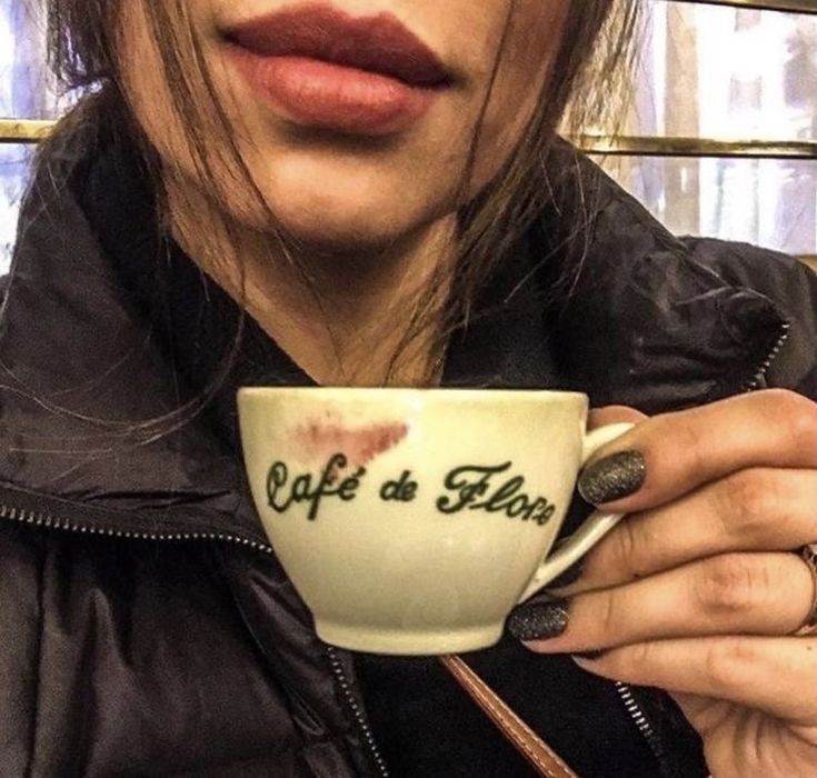 a close up of a person holding a coffee cup