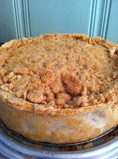 a pie sitting on top of a metal pan covered in crumbly toppings