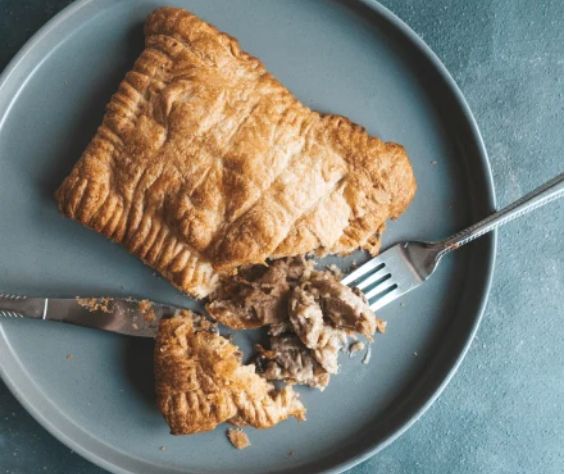 a piece of meat pie on a plate with a fork