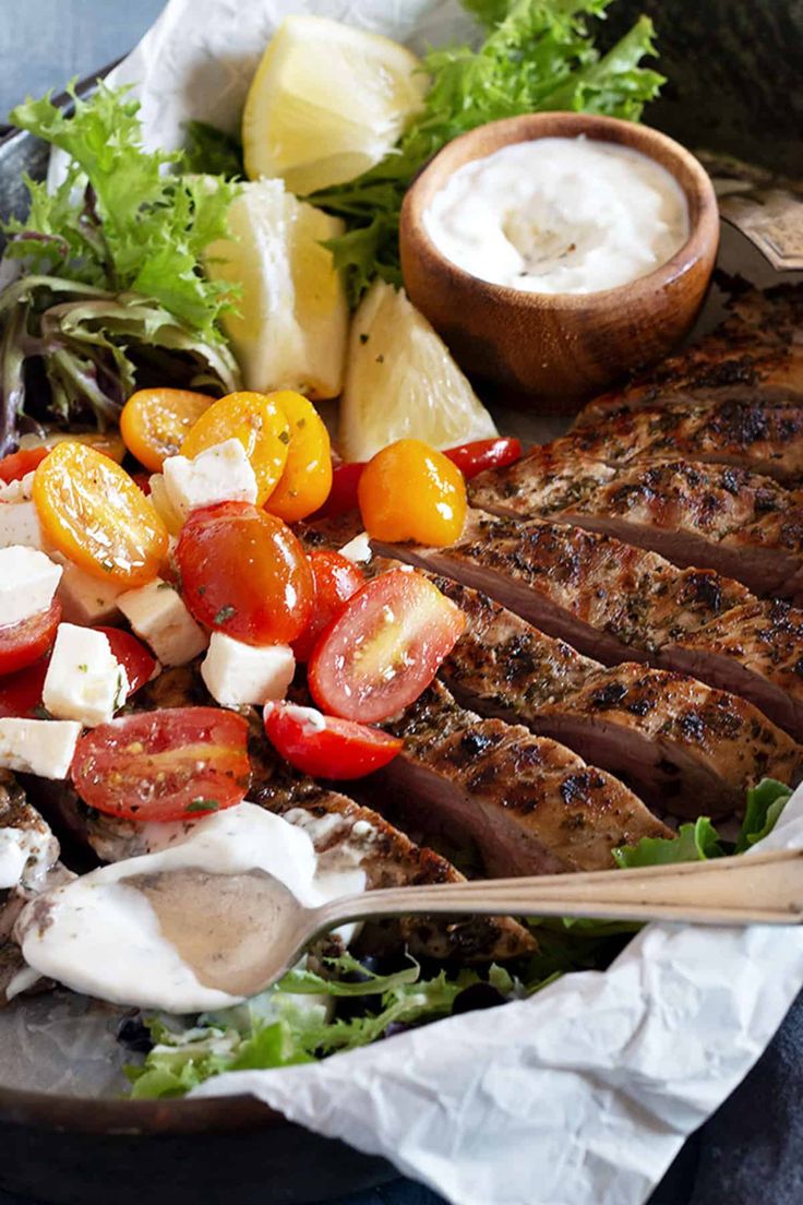 a bowl filled with meat, vegetables and dressing