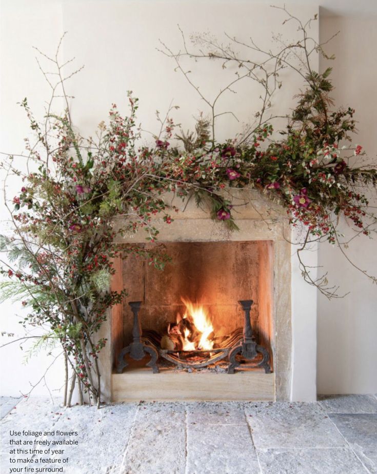 the fireplace is decorated with red berries and greenery, while the fire burns in it