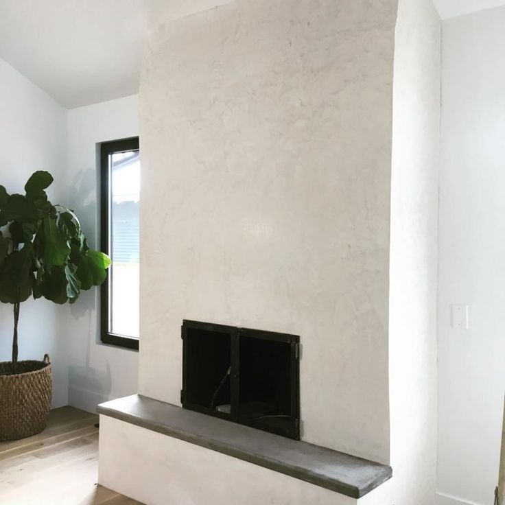 a living room with a fireplace and potted plant