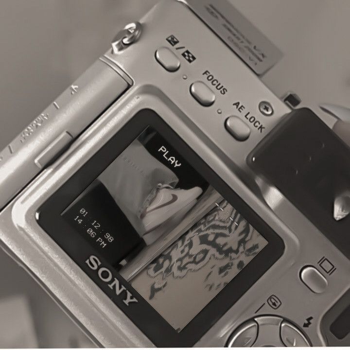 a person holding up a digital camera