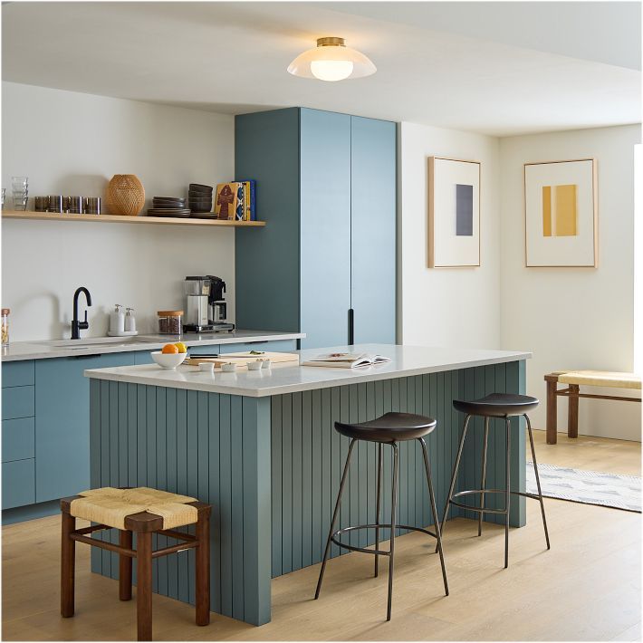 a kitchen with two stools next to an island