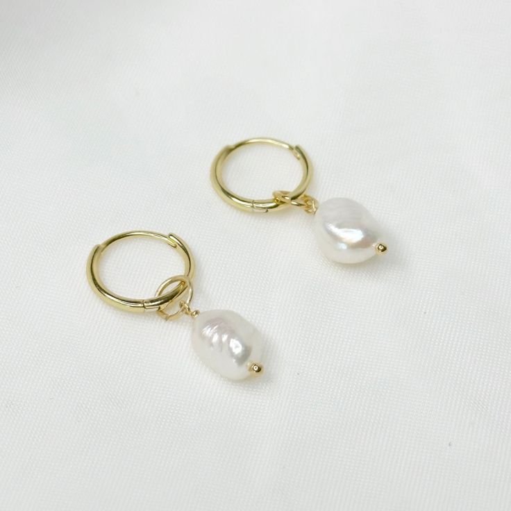 Inspired by the beautiful waters of Venice, the gorgeous Venice huggies feature a brilliant real freshwater pearl charm. They are 925 Sterling Plated Plated and super comfy to sleep in so you never have to take them off, making them the perfect everyday piece. Pair them with our Sydney huggies for a bolder look. ♡ Handcrafted ♡ 14k Gold Plated Plated on Sterling Silver  ♡ Water Resistant ♡ Natural Freshwater Pearl ♡ Hypoallergenic  ♡ Available in both 10mm and 13mm Huggies Please note all our pe 14k Gold Filled Pearl Drop Huggie Jewelry, 14k Gold-filled Pearl Drop Huggie Jewelry, Delicate Huggie Jewelry Gift, Elegant Adjustable Hypoallergenic Huggie Earrings, Adjustable Pearl Charm Earrings As Gift, White Huggie Earrings As Gift, Gold Pearl Huggie Earrings For Wedding, Minimalist 14k Gold Filled Huggie Earrings With Pearl Charm, Minimalist Pearl Pendant Earrings For Anniversary