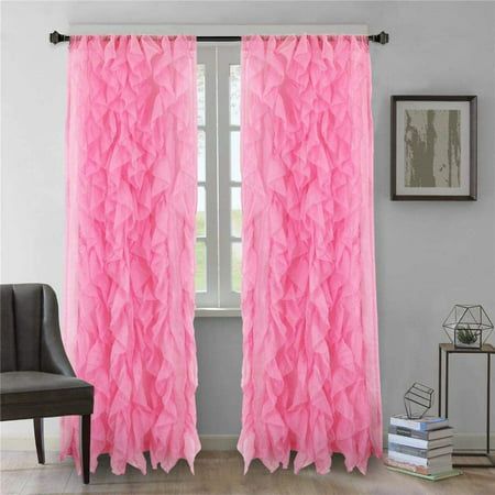 pink ruffled curtains hanging in front of a window with a chair next to it