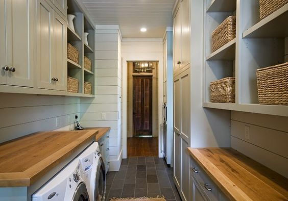 a long narrow laundry room with lots of cabinets