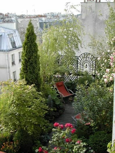 an outdoor garden with lots of plants and flowers on the side of a building in paris, france