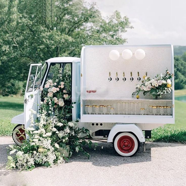 an ice cream truck decorated with flowers and greenery