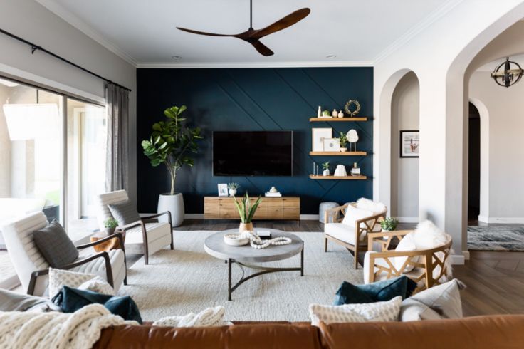 a living room filled with furniture and a flat screen tv mounted to the wall above it