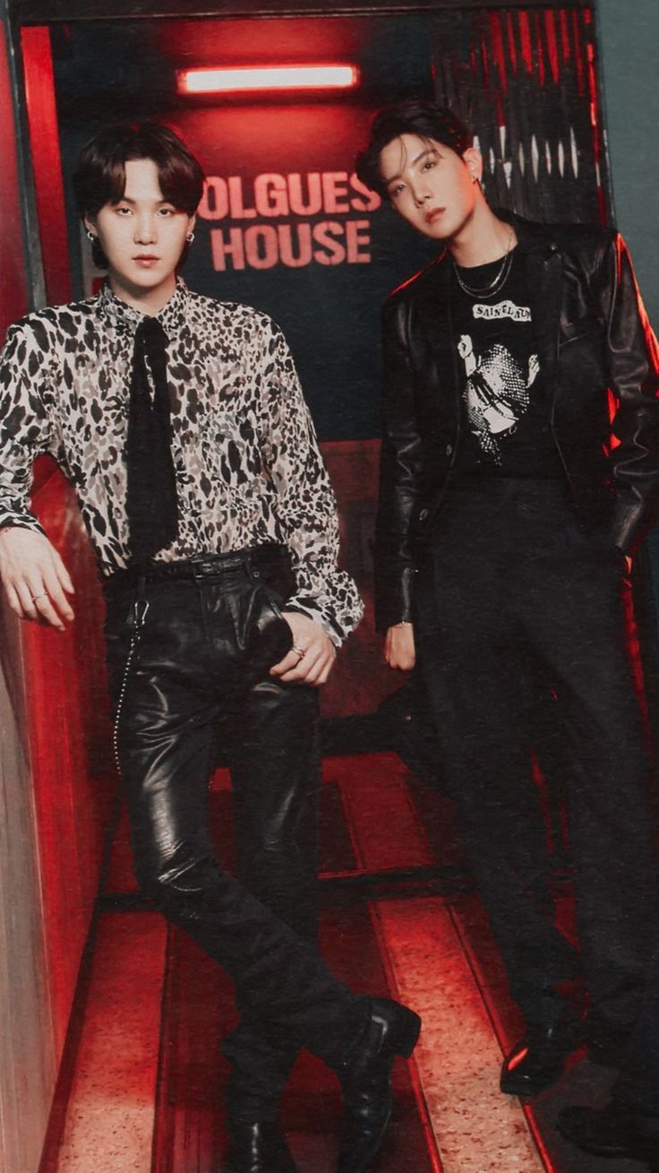 two young men standing next to each other in front of a red neon sign that reads dolces house