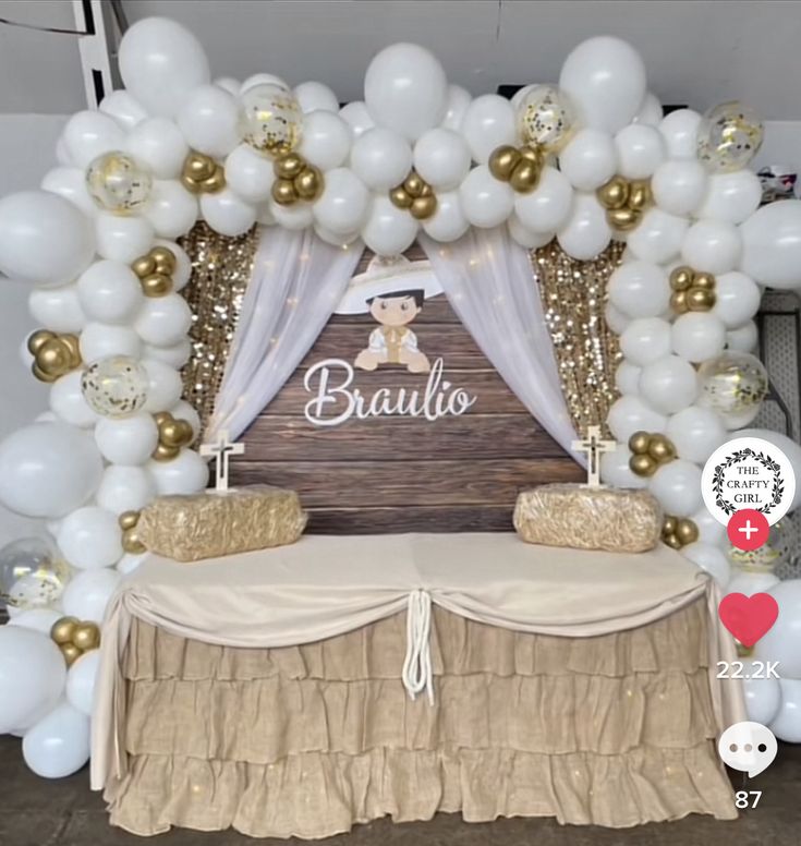 a baby shower is set up with white and gold balloons, an arch over the bed