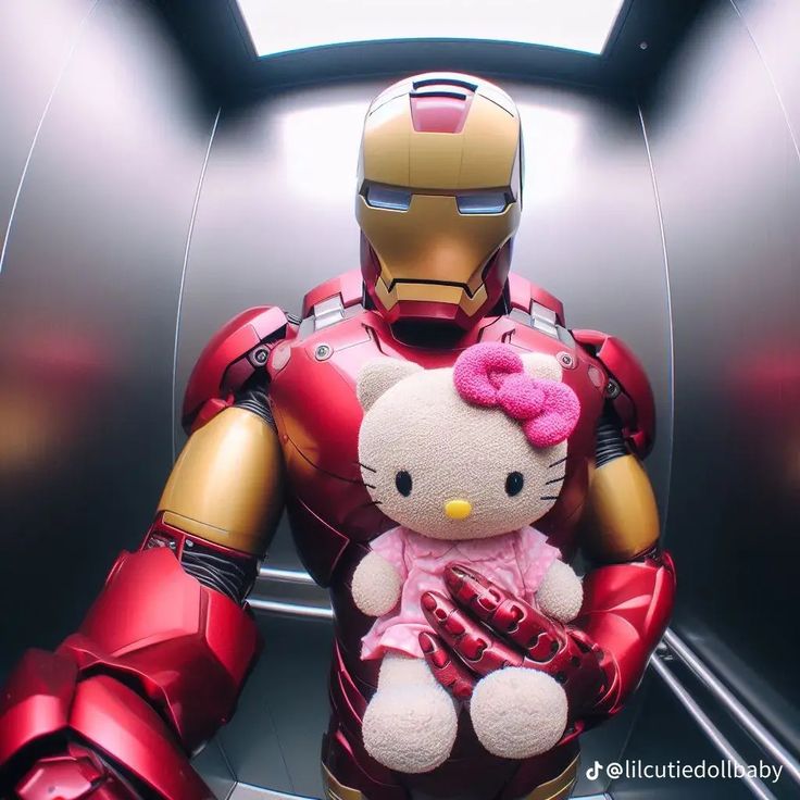 a hello kitty teddy bear sitting on top of a iron man suit in a room