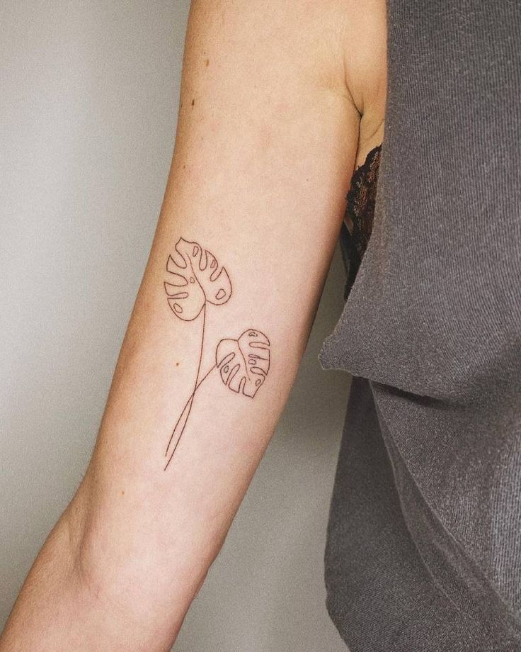 a woman's arm with a single flower tattoo on it