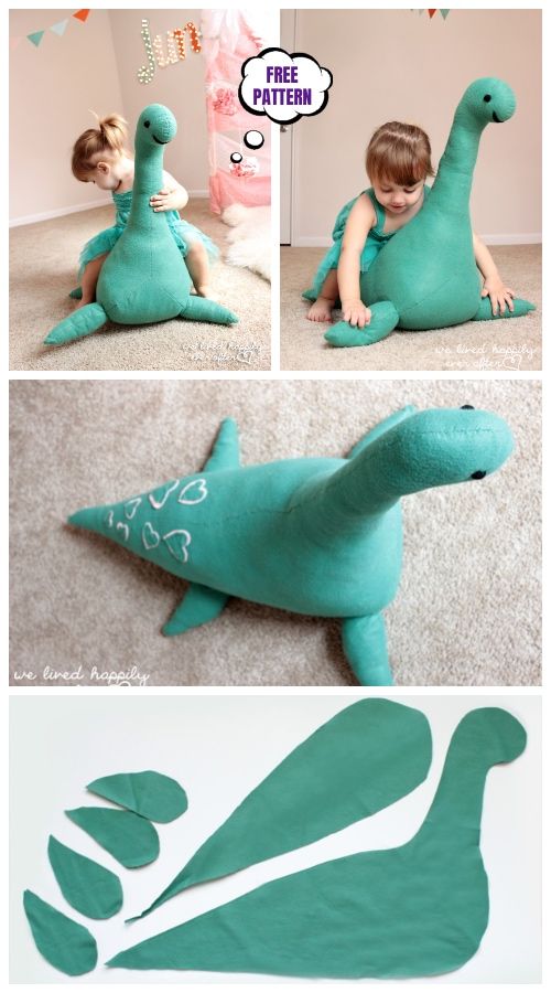 a little boy sitting on the floor next to a green dinosaur pillow with leaves cut out of it