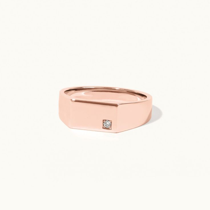 a rose gold ring with a diamond in the center and a small square stone on top