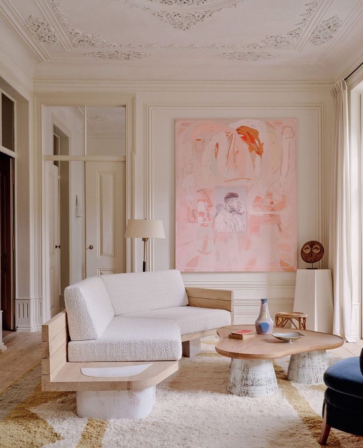 a living room filled with furniture and a painting on the wall