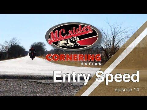 a motorcycle driving down a road next to a sign with the words cornerings on it