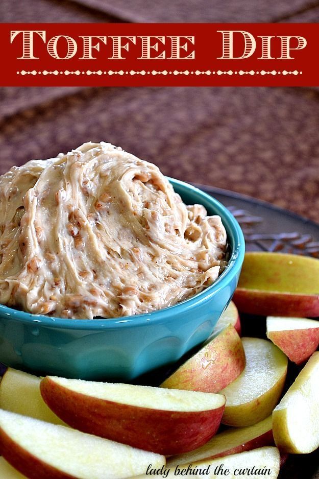 a blue bowl filled with dip next to sliced apples