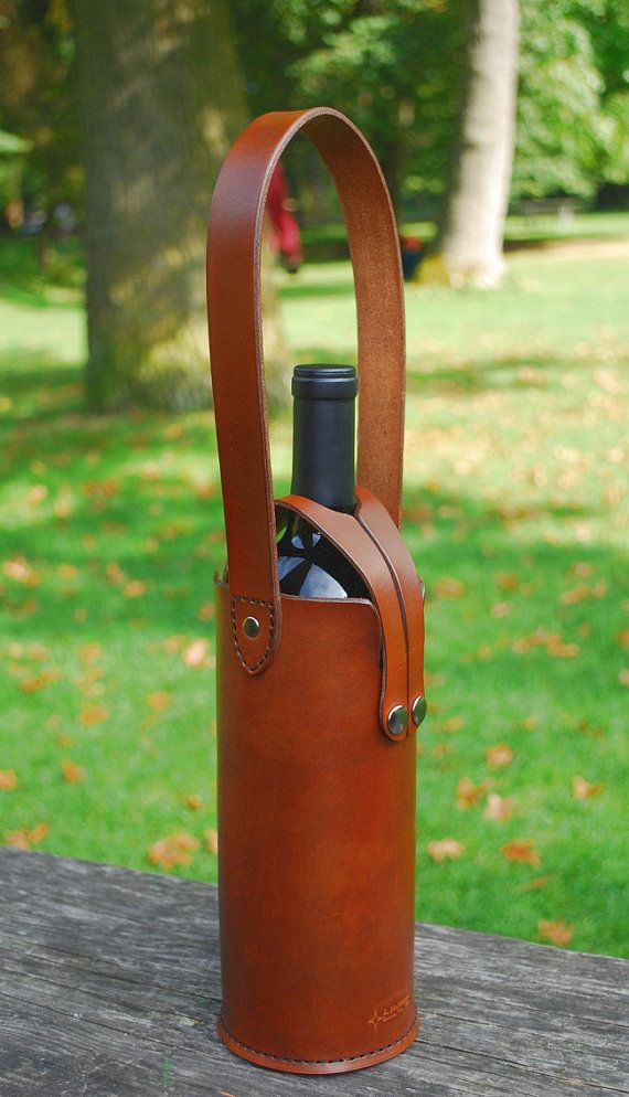 a leather wine bottle holder on a picnic table