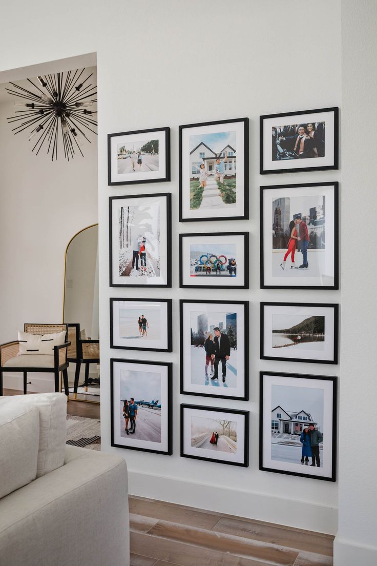 a living room with pictures on the wall and a white couch in front of it