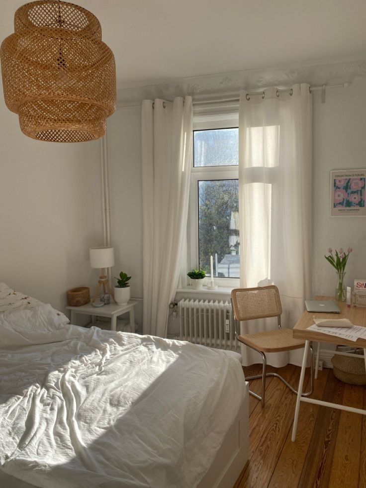 a bedroom with white walls and wooden floors