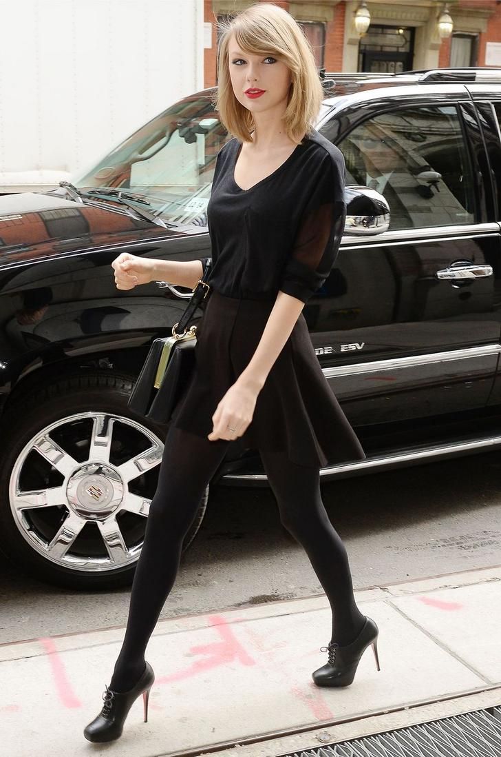 a woman walking down the street in front of a car