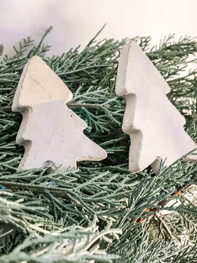 two cement christmas trees sitting on top of a tree