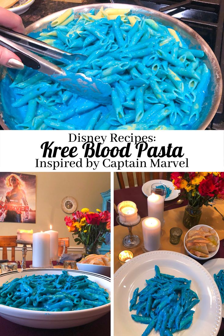 blue pasta being cooked in a pan with candles and flowers on the table behind it