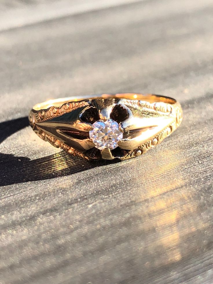 A sweet early Art Deco belcher style Diamond ring. This 1920's ring features a stunning near colorless 0.20 carat old European cut Diamond set beautifully in a simple yet elegant 14k yellow gold (stamped) ring. It's adorned with beautiful carving along the shanks adding to the timeless look. The Diamond is held in place by the distinctive belcher style six prongs and I must say these pictures don't do this Diamond justice, the fire it gives off in the sunlight is just amazing! The ring weighs 1.7 grams and feels very lightweight which is easy on the hand. It's a size 7 and is This would be a great addition to the collection of any antique jewelry lover. Condition: Good with minor wear commensurate with age. Please see pictures for details. They're considered part of the description. NOTE: Victorian 14k Gold Diamond Cut Rings, Classic Jewelry With Single Cut Diamonds, Vintage Oval Diamond Ring With Single Diamond, Vintage Oval Diamond Ring With Single Stone, Vintage Solitaire Signet Ring, Antique 14k Gold Solitaire Jewelry, Vintage Diamond Cut Signet Promise Ring, Classic Yellow Gold Diamond Ring, Antique Signet Ring With Diamond For Anniversary