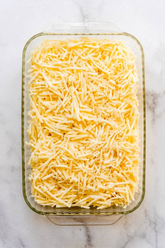 shredded cheese in a glass casserole dish